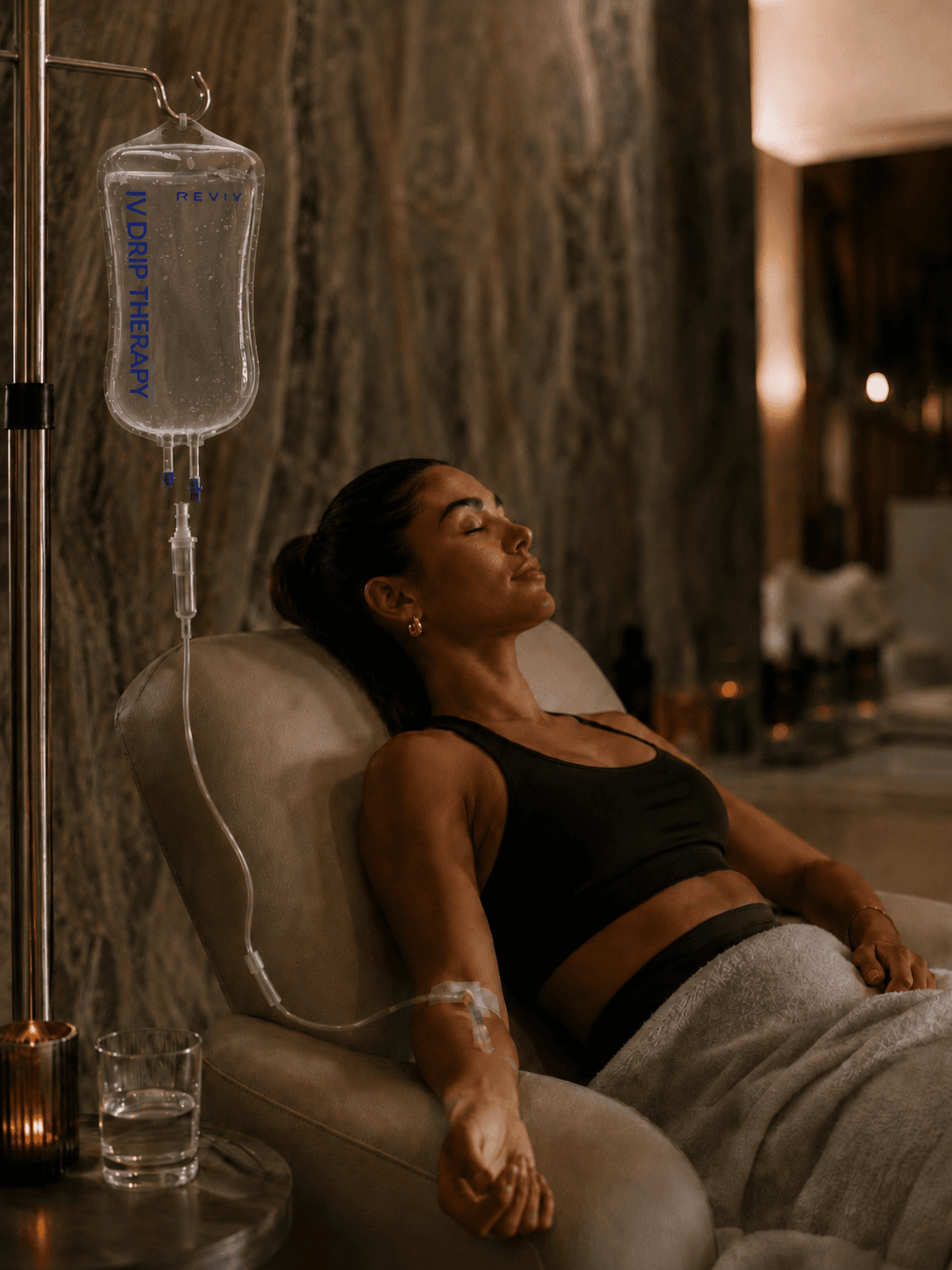 A guest reclining with an IV drip in the private IV suite at Ignite + Aliign, Ulsoor Lake, Bangalore